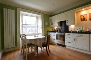 kuchnia ze stołem i krzesłami oraz oknem w obiekcie Royal Mile Elegance - Space & Luxury w Edynburgu