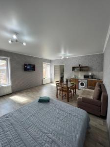 a bedroom with a large bed and a kitchen at Welcome Hotel in Kostanay