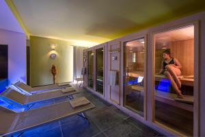 a woman sitting on a bed in a room at VOI Arenella Resort in Arenella