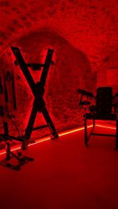 a room with red lighting and a chair and a table at Les Voûtes Secrètes - Love Room avec Balnéo à Bras in Bras