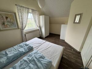 a small bedroom with a bed and a window at Friesenhus in Butjadingen