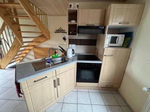 a small kitchen with a sink and a microwave at Friesenhus in Butjadingen +8 photos
