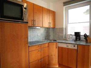 a kitchen with wooden cabinets and a microwave at Seegurke in Am Schwarzen Busch