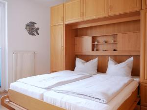a bedroom with a large white bed with a wooden headboard at Seegurke in Am Schwarzen Busch