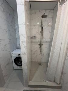 a shower in a bathroom with a washing machine at Welcome Hotel in Kostanay +52 photos