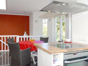 a kitchen and dining room with a table and a counter at Burg Roland Wohnung 06 in Dierhagen +13 photos