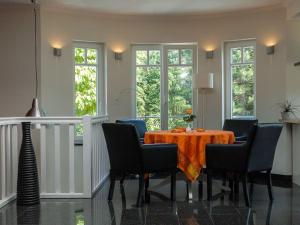a dining room with a table with chairs and windows at Burg Roland Wohnung 06 in Dierhagen