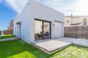 a white house with a patio and grass at Jouvacations Villa Osona in Vilafant