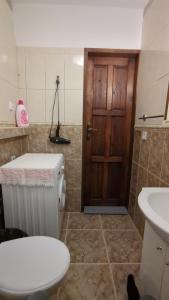 a bathroom with a toilet and a wooden door at Apartament Pola in Piła +30 photos