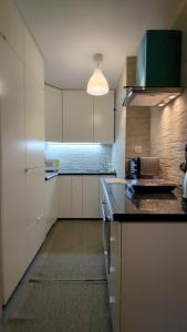a kitchen with white cabinets and a black counter top at Apartament Pola in Piła