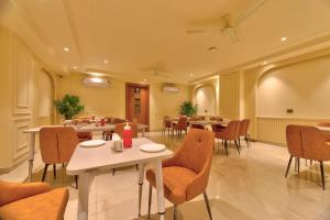 ein Restaurant mit Tischen und Stühlen in einem Raum in der Unterkunft Dwellr Luxury Stays - Golf Course Road in Gurgaon
