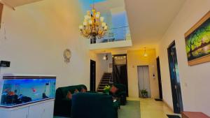 a living room with a chandelier and a fish tank at The Hotel Am Bliss in Gurgaon +16 photos