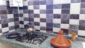 a tea kettle sitting on a stove in a kitchen at Asklou Appartement à Mirleft in Mirleft +53 photos