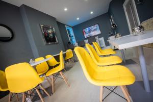 a waiting room with yellow chairs and a table at The Gables Hotel by Cherish Lewis Blackpool in Blackpool