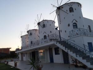 a building with a windmill on the side of it at Ξενώνες Ανεμόμυλοι - Windmills Hotel in Panayía