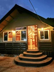 a small house with stairs leading to a door at Lolo Dads Cabin in Sagada