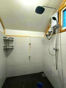 a shower with a shower head in a bathroom at Lolo Dads Cabin in Sagada
