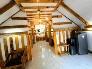a living room with wooden ceilings and a refrigerator at Lolo Dads Cabin in Sagada