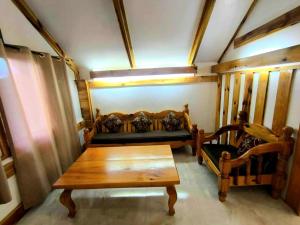 a living room with a couch and a wooden table at Lolo Dads Cabin in Sagada