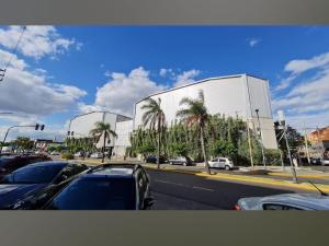 a parking lot with cars parked in front of a building at departamento completo, Luminoso, cómodo y bien ubicado ideal eventos river movistar arena tecnopolis in Munro