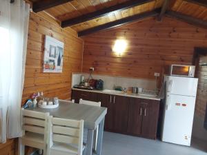 a kitchen with a table and a white refrigerator at Chen Ba'Galil in Kahal