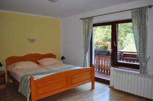 Schlafzimmer mit einem Bett und einem Fenster mit einem Balkon in der Unterkunft Prenočišča Valentina in Solčava