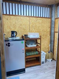 a small kitchen with a refrigerator and a tv at Panan Homestay Kohpu in Ban Na