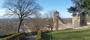 an old stone building on a hill with a tower at Charmant studio - Centre historique de Crémieu in Crémieu