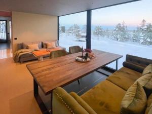 a living room with a wooden table and a large window at Modern Cabin At Blefjell in Svene +26 photos