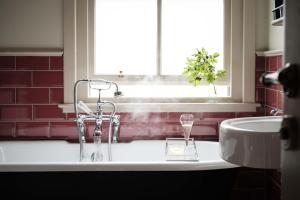 a bathroom with a tub and a sink and a window at The Grandtully Hotel in Grandtully