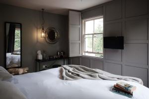 a bedroom with a white bed and a mirror at The Grandtully Hotel in Grandtully