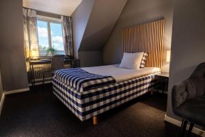 a hotel room with a bed and a window at Hotell Gillet i Köping in Köping