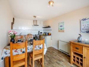 a kitchen and dining room with a table and chairs at Golygfa Hudol - Uk46712 in Pwllheli