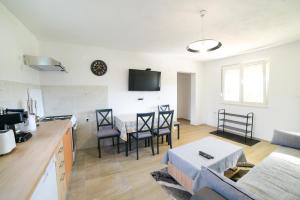 a kitchen and living room with a table and chairs at Apartman Šarabaća in Bajagić