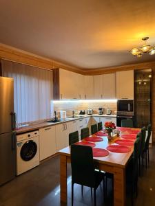 a kitchen with a long table with chairs and a kitchen with a tableablish at MiS Family house з чаном та сауною in Kosiv