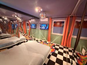 a room with two beds and a checkered floor at Capsule illusion - Switch 2 - Mons Centre in Mons