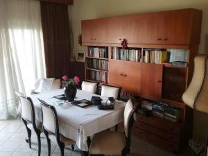 a dining room table with chairs and a book shelf at Maisonette Afroditi in Perea