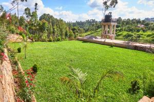 a field of green grass with a monument in the background at Eliper Hotel in Gatura