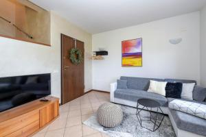 a living room with a couch and a tv at Villa Bella by Garda FeWo in Manerba del Garda