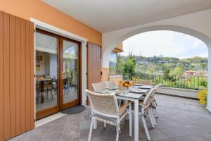 a dining room with a table and chairs on a patio at Villa Bella by Garda FeWo in Manerba del Garda