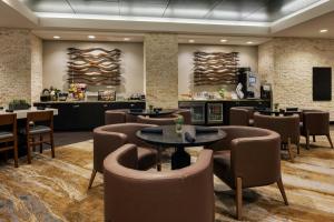 a restaurant with tables and chairs and a bar at Wichita Marriott in Wichita