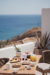 a table with food on it with a view of the ocean at Armony Suites Milos in Paliochori