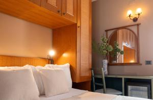 a bedroom with a bed and a desk and a mirror at Hotel Sirio in Lampedusa