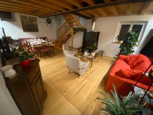 a living room with a red couch and a table at Agriturismo Giorgio Colutta in Manzano