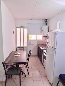 a kitchen with a table and a white refrigerator at Gotas de Rocio N1 in San Antonio Oeste +3 photos