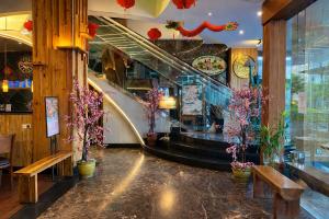 a lobby with stairs and flowers in a store at Smart Hotel Thamrin Jakarta in Jakarta