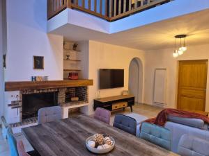 a living room with a table and a fireplace at Le nid des Pyrénées in Vielle-Aure