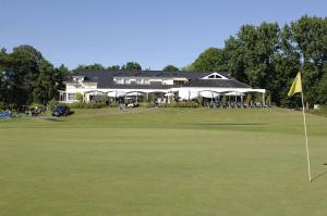 ein Putting Green mit einem Haus im Hintergrund in der Unterkunft Golfhotel Rheine Mesum in Rheine