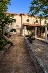 a large brick building with a stone driveway at Holiday home Bilini Dvori - house with swimming pool in Garci