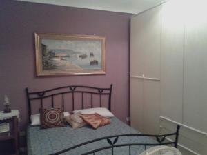 a bedroom with a bed and a painting on the wall at Appartamento le Porte di Ortigia in Siracusa